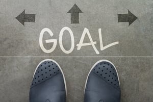 Hand drawn GOAL design word on front of business man feet as concept